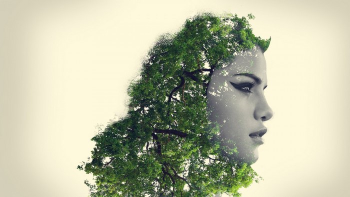 Double exposure of a woman's face and a tree