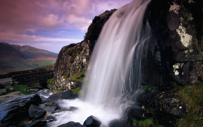 Waterfall cascading over rocks in a mountainous landscape