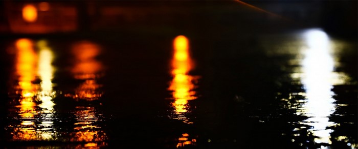Nighttime reflections of lights on wet pavement
