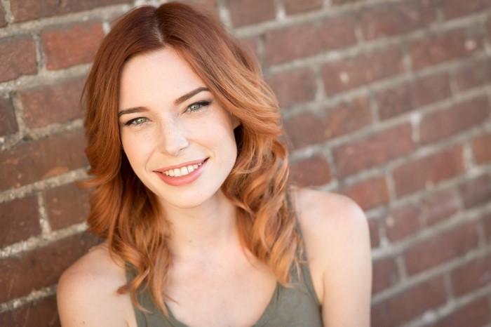 Woman with red hair and freckles smiling