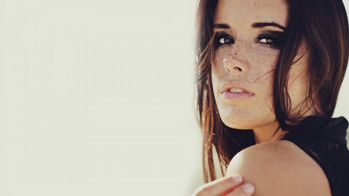 Woman with freckles looking over her shoulder