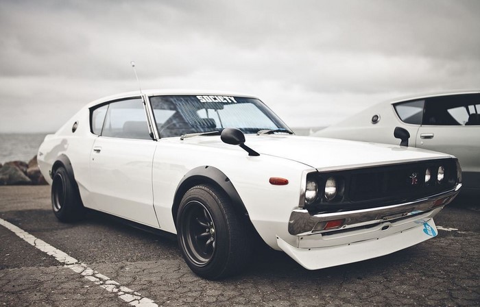 White Nissan Skyline GT-R coupe parked by the water