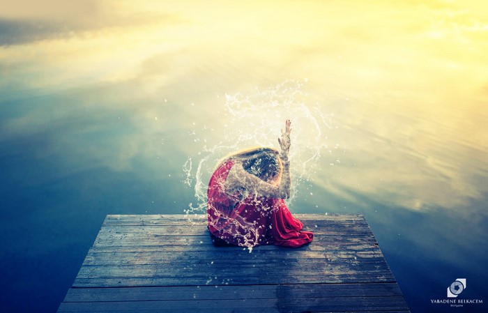 Woman in red dress on dock with water splashes