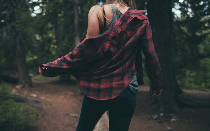 Woman wearing plaid shirt in forest