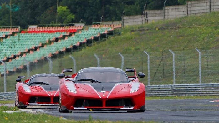 Two red Ferrari FXX K cars on a race track
