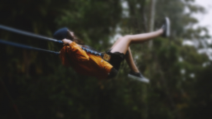 Person on a swing in a forest