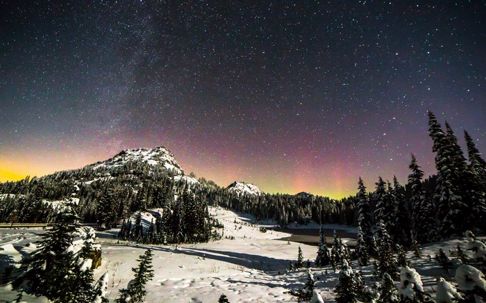 Aurora Borealis over snow-covered mountains at night