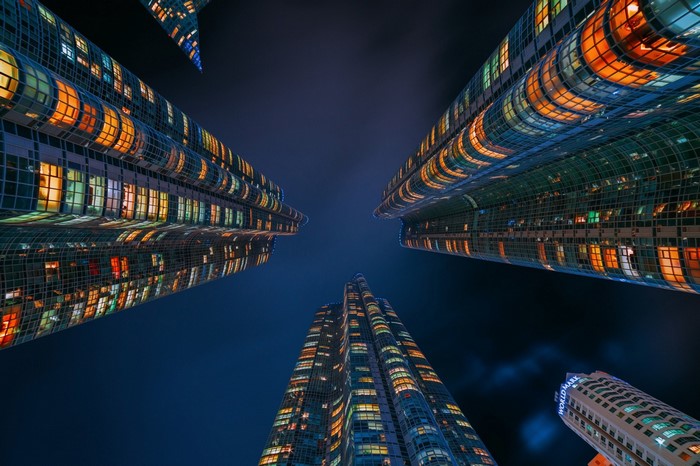 Skyscrapers at night with colorful lights, worm's eye view