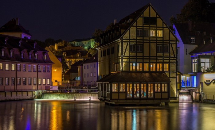 Night view of historic buildings along a canal in Bamberg, Germany