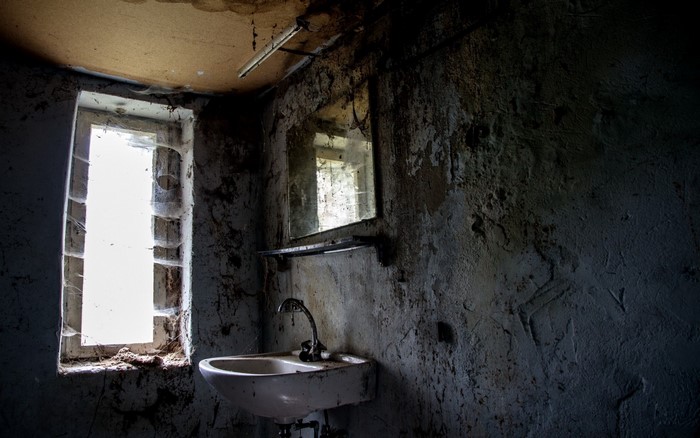 Abandoned bathroom with sink and window
