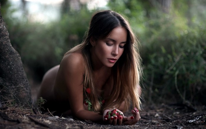 Woman with strawberries in forest