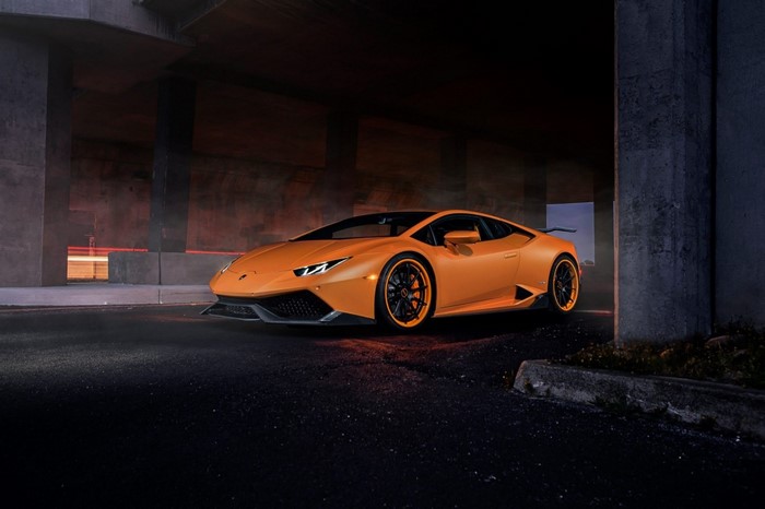 Orange Lamborghini Huracan parked under a bridge