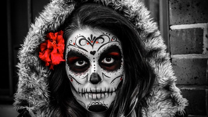 Woman with Sugar Skull makeup and red flower