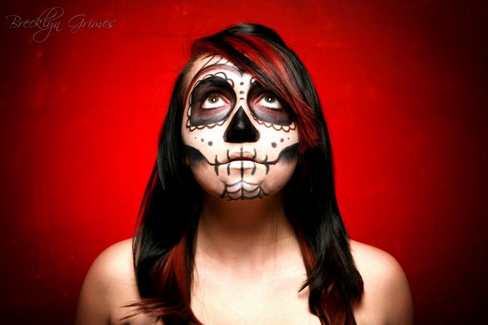 Woman with Sugar Skull makeup and red background