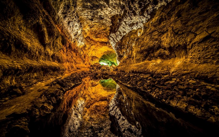 Illuminated Cave with Water Reflection
