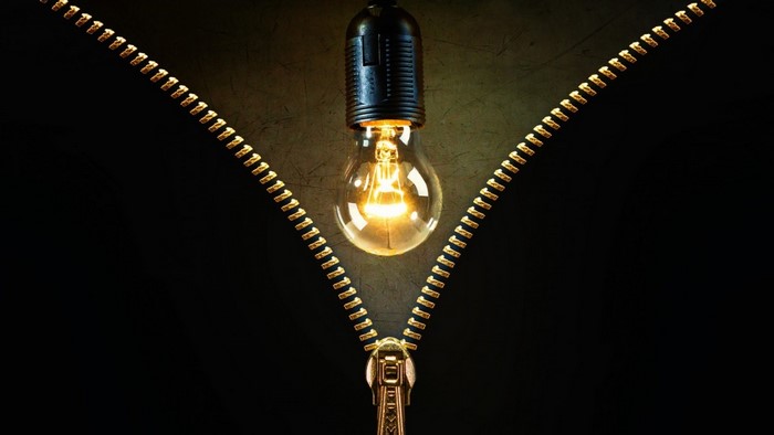 Lightbulb behind a zipper on a dark background