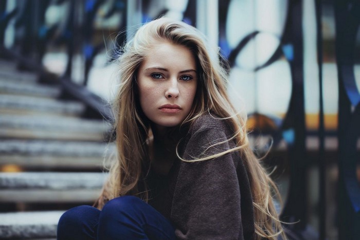 Woman with long blonde hair sitting on steps