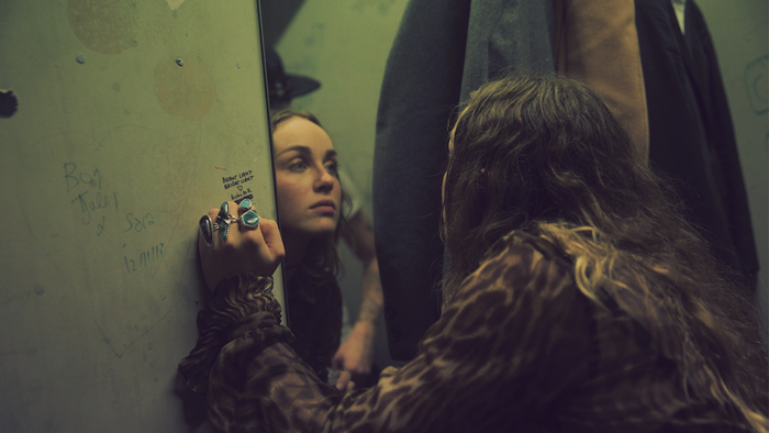 Zella Day looking in a mirror
