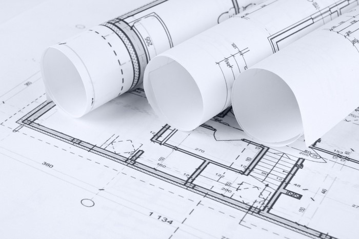 Architectural blueprints rolled up on a table