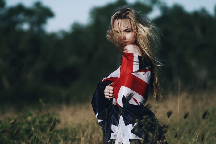 Woman wrapped in Australian flag in a field