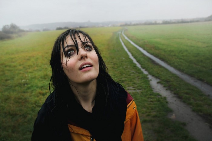 Woman with wet hair looking up in a field