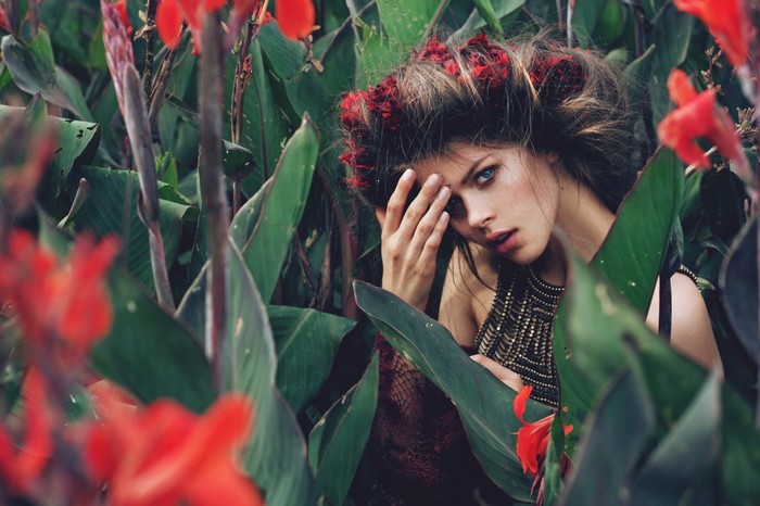 Woman with red flowers in hair in a garden