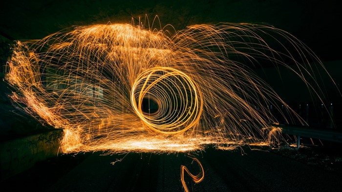 Steel wool spinning creating light trails at night