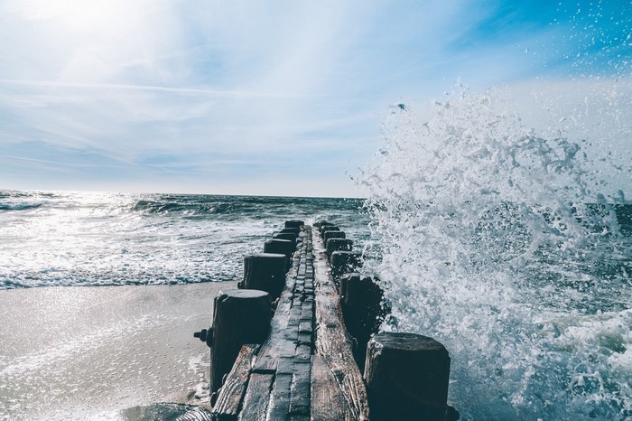 Waves crashing on a wooden pier at the sea