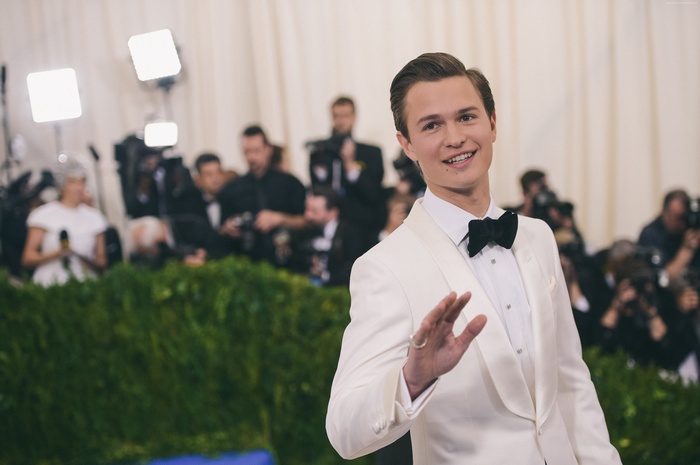 Ansel Elgort in a white tuxedo waving