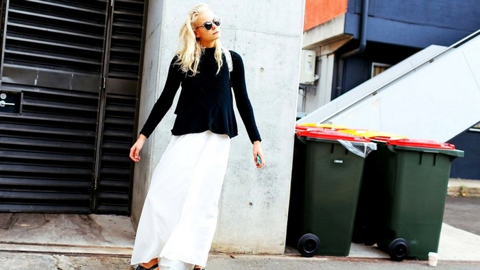 Woman in black top and white skirt on street
