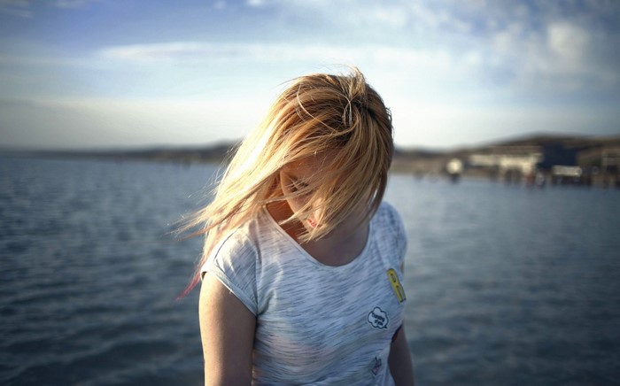 Woman with blonde hair by the sea
