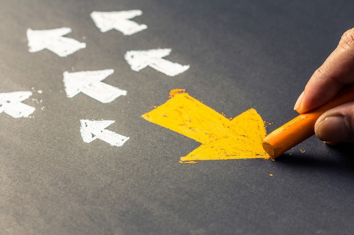 Hand drawing a yellow arrow with chalk