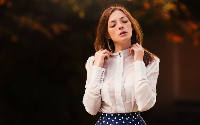 Olga Kobzar in a white shirt and polka dot skirt