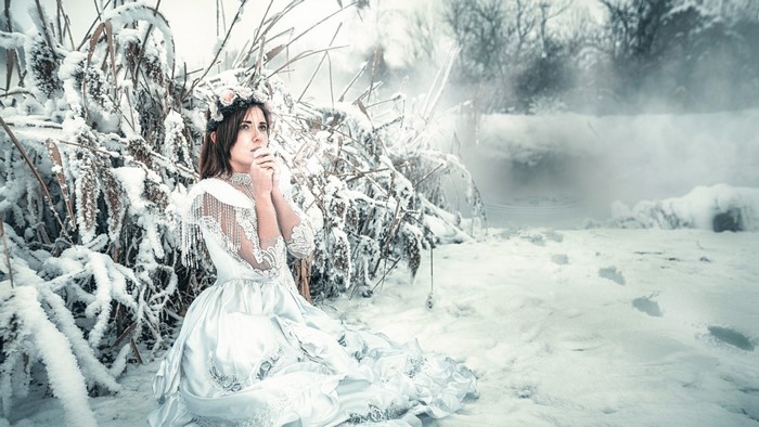 Woman in white dress in snowy landscape
