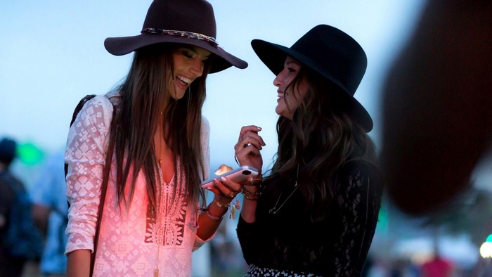 Two women in hats looking at a phone