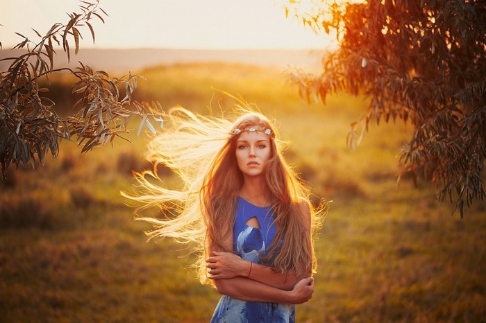 Woman with long hair and flower crown at sunset