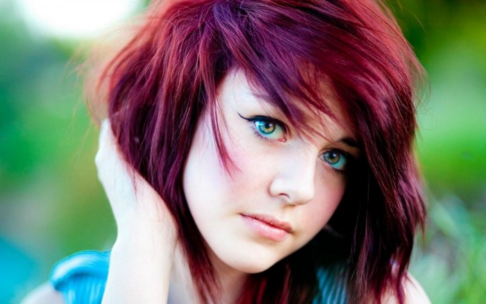 Young woman with dyed red hair and blue eyes
