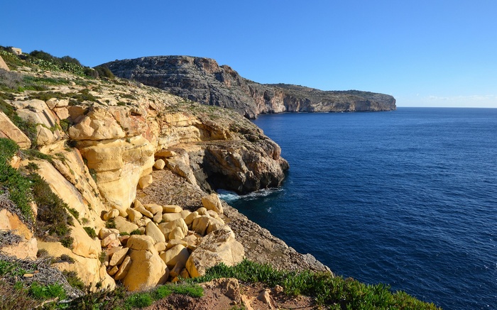 Rocky coastline overlooking the blue sea under a clear sky