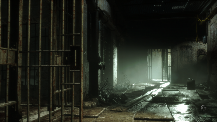 Lara Croft in a dark prison corridor in Rise of the Tomb Raider
