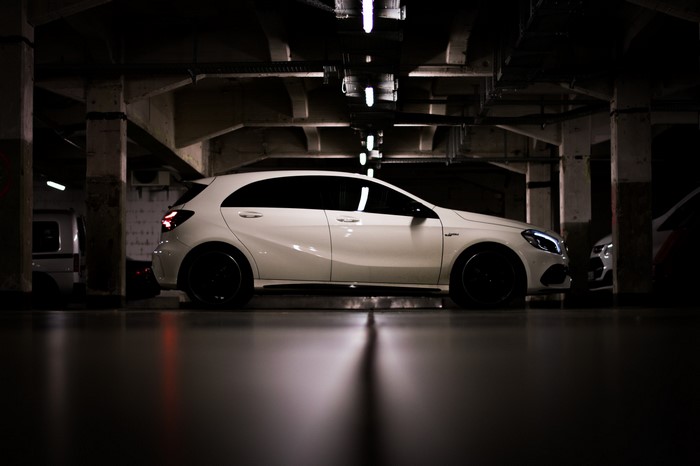White Mercedes-Benz A45 AMG parked in a dark garage