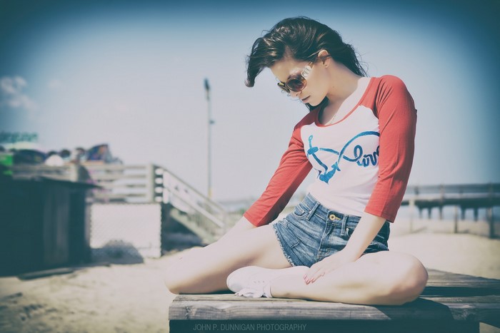 Woman in sunglasses and jean shorts on a beach