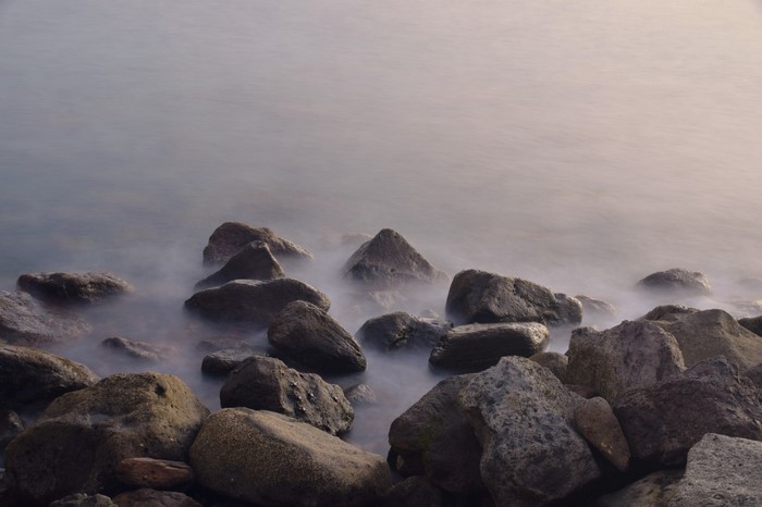 Rocks on the shore with long exposure water