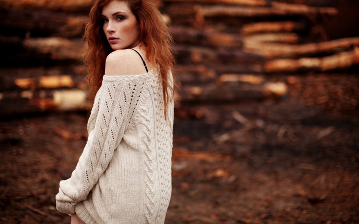 Woman with red hair wearing a cream sweater