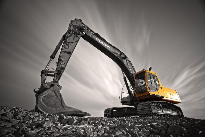 Yellow Volvo excavator on rocky terrain