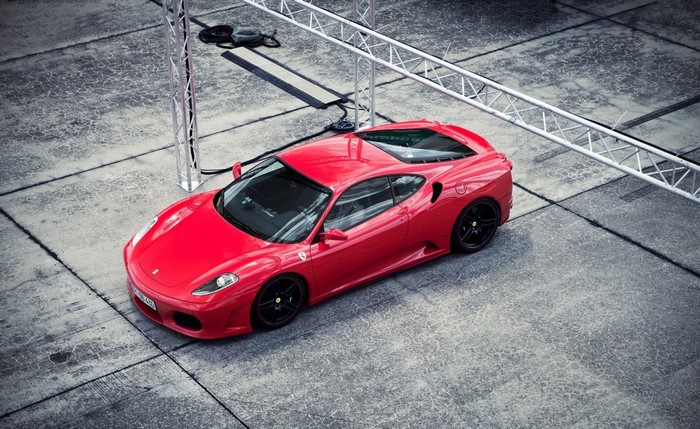 Red Ferrari F430 parked on concrete