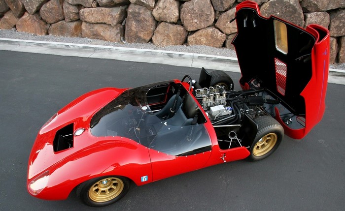 Red vintage sports car with open hood and engine