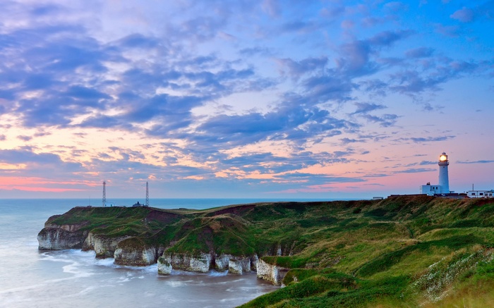 Lighthouse on a cliff overlooking the sea at sunset