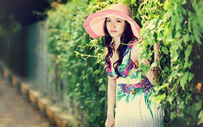 Asian woman in a floral dress and hat