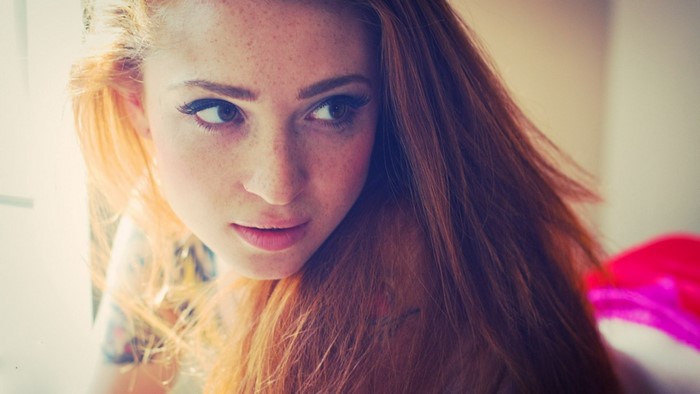 Woman with red hair and freckles looking away