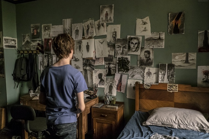 Nicholas Hamilton in a room with drawings